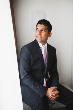 Güzel adam, damat poz veriyor ve düğüne hazırlanıyor.