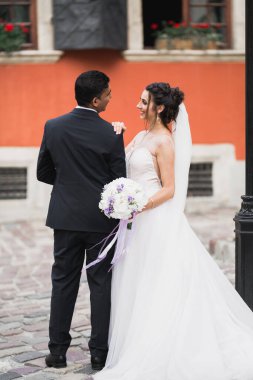 Güzel, mutlu bir düğün çifti, güzel şehirde uzun beyaz elbiseli bir gelin.