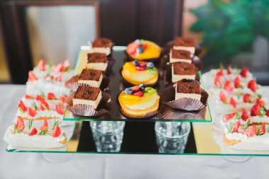 Çeşitli lezzetli tatlılar, yemek fikirleri ve kutlamalarla dolu bir büfe.