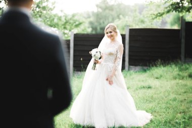 Parkta poz veren gelinlikli güzel, lüks bir gelin.