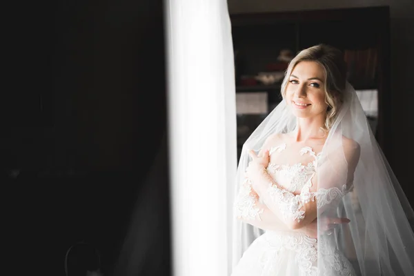 Noiva de luxo em vestido branco posando enquanto se prepara para a cerimônia de casamento — Fotografia de Stock