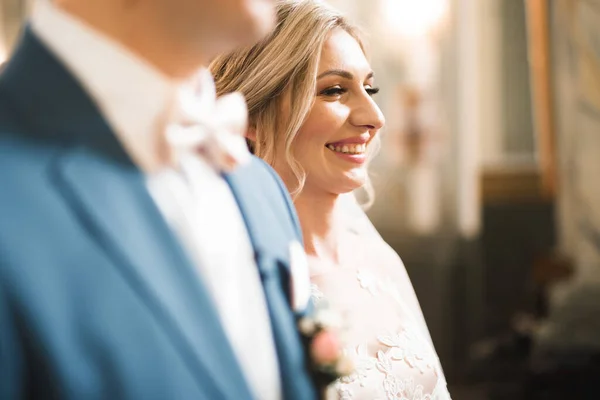 Bröllopspar bida och brudgum gifta sig i en kyrka — Stockfoto