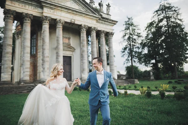 Coppia appena sposata che corre e salta nel parco mentre si tiene per mano — Foto Stock