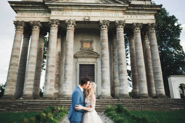 Hermosa novia y novio abrazar y besar en su boda al aire libre —  Fotos de Stock