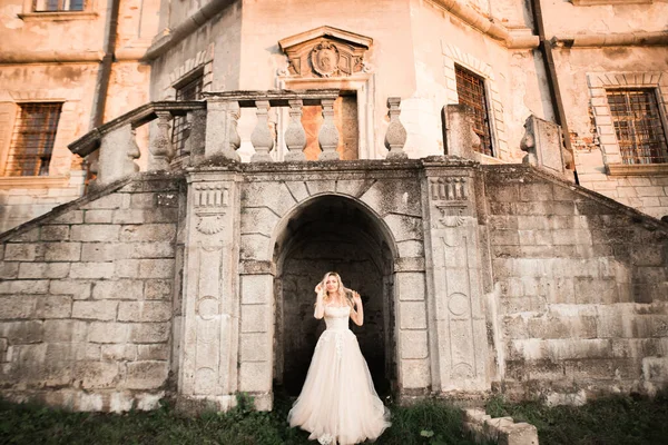 Bella giovane sposa di lusso in abito da sposa in posa vicino al castello — Foto Stock