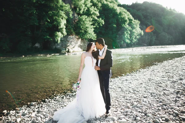 La pareja de boda en la naturaleza se está abrazando. Hermosa modelo chica en vestido blanco. Hombre de traje —  Fotos de Stock