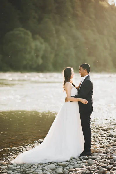 Hochzeitspaar in der Natur umarmt sich. Schöne Modell Mädchen in weißem Kleid. Mann im Anzug — Stockfoto