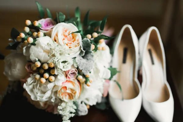 Bruiden bruiloft schoenen met een boeket met rozen en andere bloemen — Stockfoto