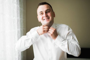 Güzel adam, damat poz veriyor ve düğüne hazırlanıyor.