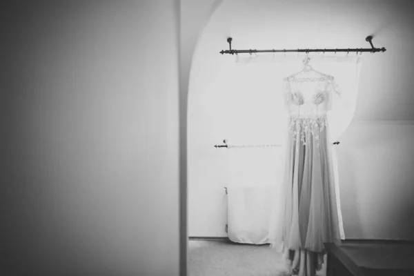 The perfect wedding dress with a full skirt on a hanger in the room of the bride — Stock Photo, Image