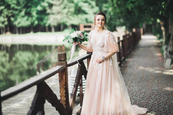 Retrato de novia impresionante con el pelo largo posando con gran ramo — Foto de Stock