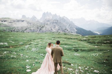 Dağların arka planında sevgi dolu bir koca ve kadın. Sevgili çift duygusal olarak vakit geçirir.