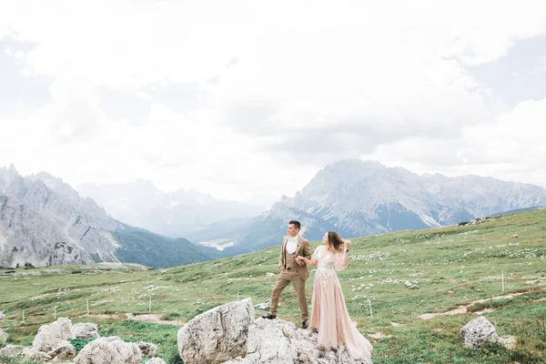 Prachtige prachtige bruid poseren om bruidegom en plezier in de buurt in de bergen met een prachtig uitzicht, ruimte voor tekst, bruiloft paar — Stockfoto