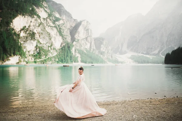 Bella sposa posa vicino rocce sullo sfondo le montagne — Foto Stock