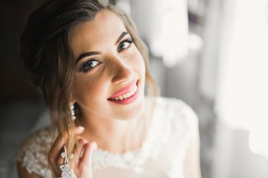 Beyaz elbiseli lüks gelin düğün törenine hazırlanırken poz veriyor.