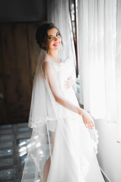 Linda noiva em roupão posando e se preparando para o rosto cerimônia de casamento em uma sala — Fotografia de Stock