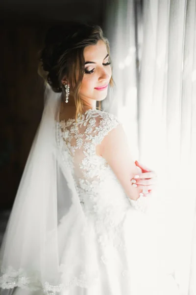 Beyaz elbiseli lüks gelin düğün törenine hazırlanırken poz veriyor. — Stok fotoğraf