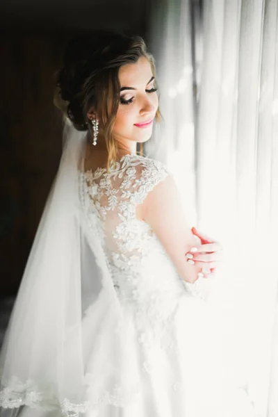 Noiva de luxo em vestido branco posando enquanto se prepara para a cerimônia de casamento — Fotografia de Stock