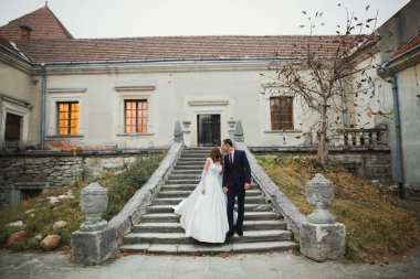 Güzel gelin ve damat düğün günlerinde kucaklaşıp öpüşürler.