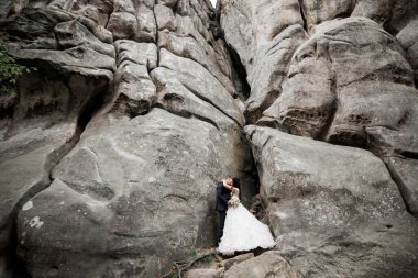Dağların arka planında sevgi dolu bir koca ve kadın. Sevgili çift duygusal olarak vakit geçirir.