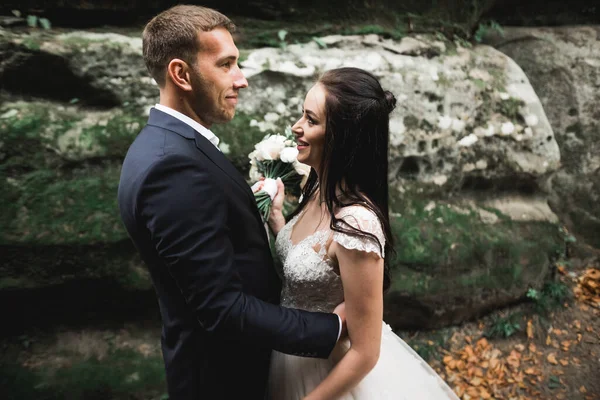 Linda noiva linda posando para noivo e se divertindo perto de montanhas com vista incrível, espaço para texto, casal de casamento — Fotografia de Stock