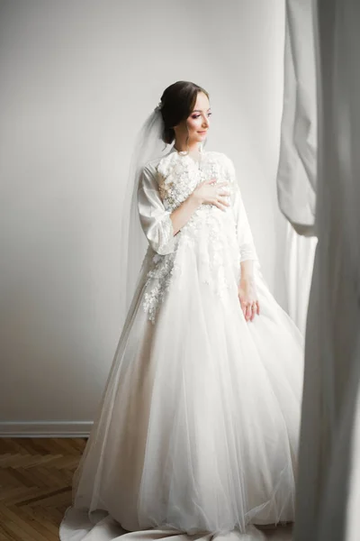 Gyönyörű menyasszony visel divat esküvői ruha tollak luxus öröm smink és frizura, stúdió beltéri fotózás — Stock Fotó