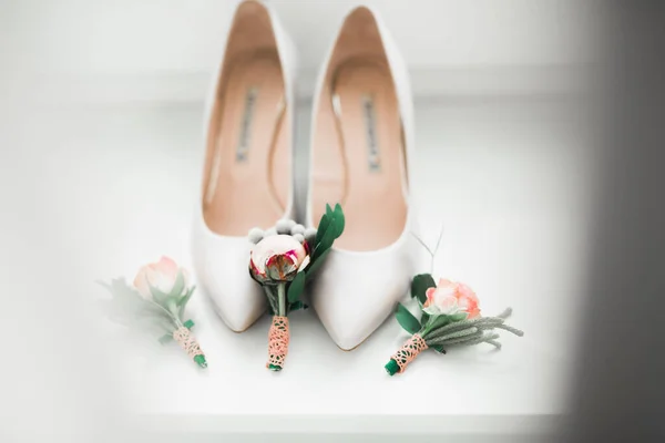 Een paar elegante en stijlvolle bruidsschoenen met een boeket met rozen en andere bloemen — Stockfoto