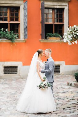 Doğadaki düğün çifti birbirine sarılıyor. Beyaz elbiseli güzel bir kız. Takım elbiseli adam