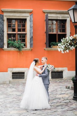 Doğadaki düğün çifti birbirine sarılıyor. Beyaz elbiseli güzel bir kız. Takım elbiseli adam