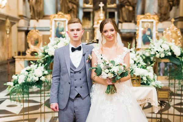 Gifta par poserar i en kyrka efter ceremoni — Stockfoto