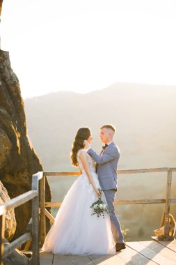 Göz kamaştırıcı mutlu çift birbirine yakın duruyor ve gözlerinin içine bakıyor.