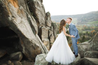Güzel gelin ve damat evlendikleri gün kucaklaşıp öpüşüyorlar.