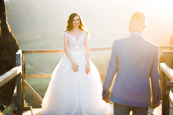 Feliz boda hermosa pareja novia y novio en el día de la boda al aire libre en la roca montañas. Feliz matrimonio pareja al aire libre en la naturaleza, luces suaves y soleadas — Foto de Stock