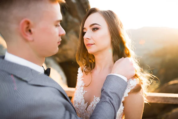 Bröllopspar på naturen kramar varandra. Vacker modell flicka i vit klänning. Man i kostym — Stockfoto