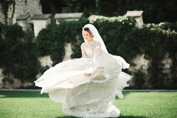 Hermosa novia joven de lujo en vestido de novia posando en el parque —  Fotos de Stock
