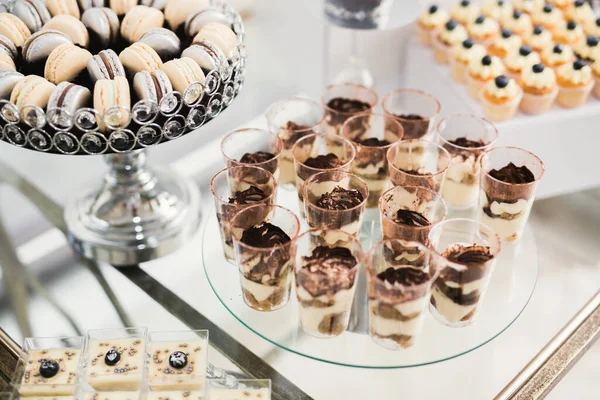 Läckra och välsmakande dessert bord med muffins och skott i receptionen närbild — Stockfoto