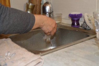 Kirli bulaşıkları yıkayan bir kadın.