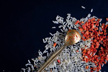 Siyah arka planda baharatlı pirinç, safran, metal Spoo