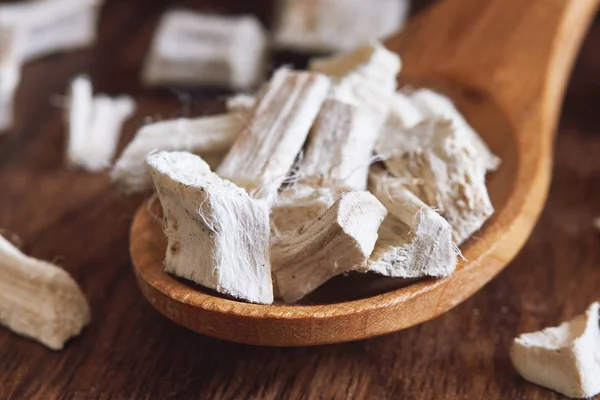 Kurutulmuş ve dilimlenmiş hatmi kökü (Althaea officinalis) tahta kaşık