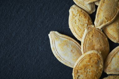 Kavrulmuş ve tuzlu Kabakçekirdeği rustik siyah arka plan üzerine. Kopya alanı ile Üstten Görünüm