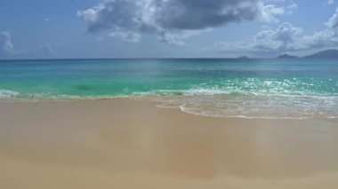 Hassas Dalgalar Bu stok video tropik bir plajın kumlu sahilinde yuvarlanan narin okyanus dalgalarını gösterir.