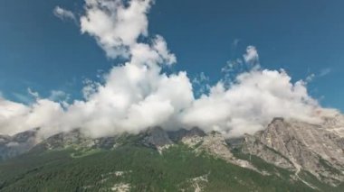 Clouds passing above mountains. It can be useful for intros, presentations, title reveals and much more. It will work great for a nature related videos, TV shows about the travel or vacations or any other video requiring clouds over mountains.