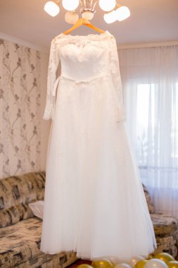 Gelinlik avizeye asılı.