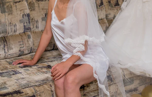 Braut in Schleier sitzt auf Sofa — Stockfoto