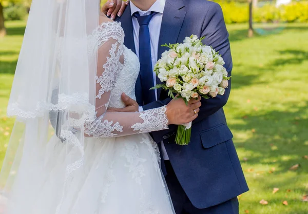 Nevěsta a ženich stojí v parku — Stock fotografie