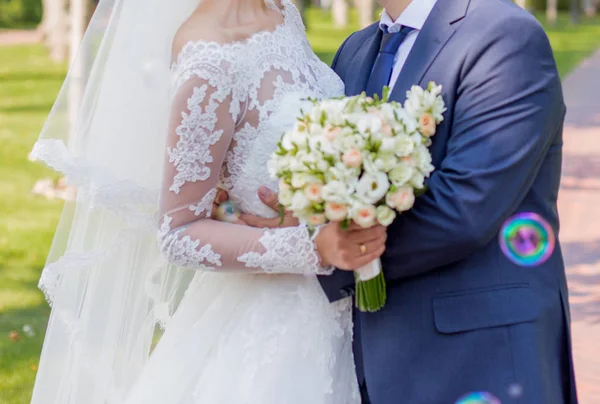 Bride and groom standing in the park — Stock Photo, Image