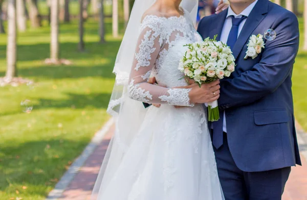 Sposa e sposo in piedi nel parco — Foto Stock