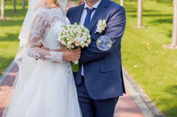 Bride and groom standing in the park — Stock Photo, Image