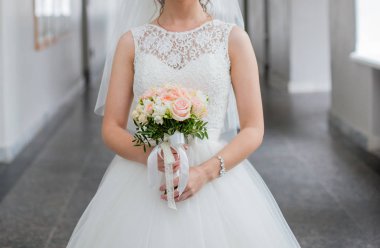 Gelin elinde bir buket düğün çiçeği tutuyor.