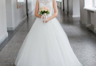 Gelin elinde bir buket düğün çiçeği tutuyor.